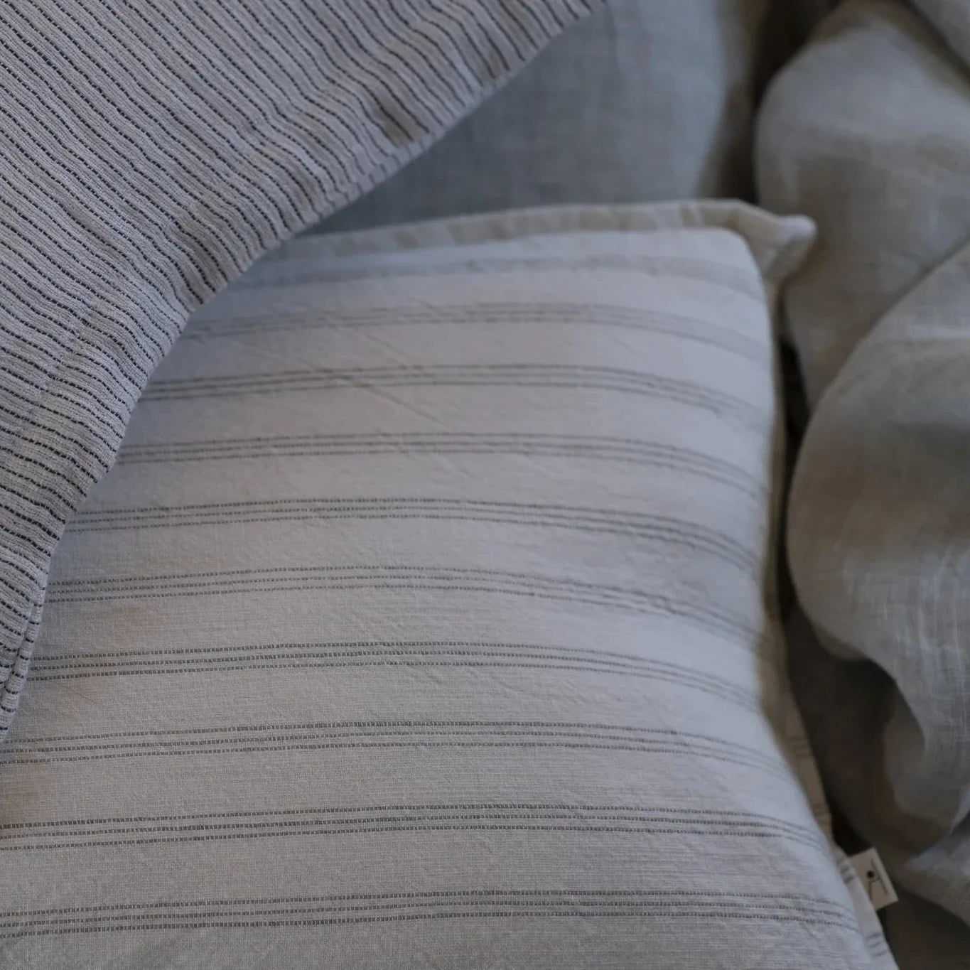 Meraki linen cotton cushion cover styled on bed